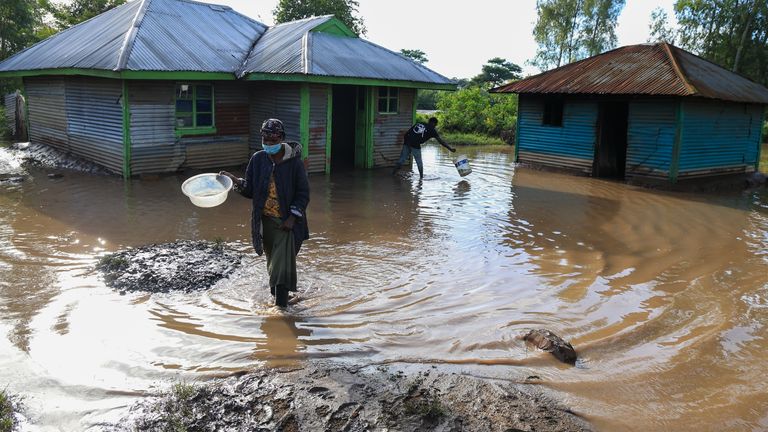 A woman walks through flood waters following heavy rains in Ahero, western Kenya. Pic: AP